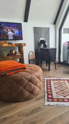 a bedroom with a large brown bed and a stove at Lukina koliba-vikendica-Manjaca in Banja Luka