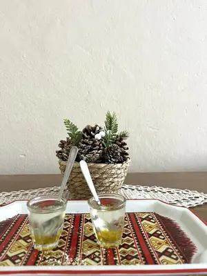 a table with two glasses and a basket of pine cones at La Simba2 in Banja Luka