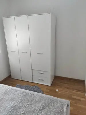 a bedroom with a white dresser and a bed at Apartman Luka in Doboj