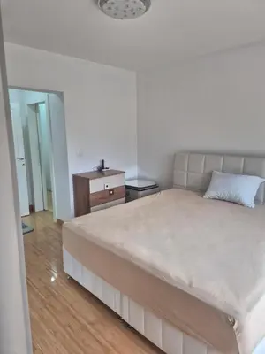 a bedroom with a large bed and a dresser at Apartmans Zenica in Zenica