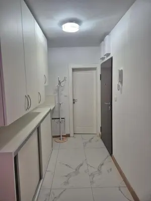 a bathroom with white cabinets and a tile floor at Apartmans Zenica in Zenica