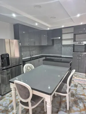 a kitchen with a table and some chairs in it at Apartmans Zenica in Zenica