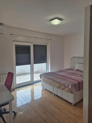 a bedroom with a bed and a window and a desk at Apartmans Zenica in Zenica