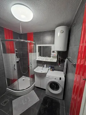 a bathroom with a toilet sink and a washing machine at Apartman Lea in Železnička Stanica Incel