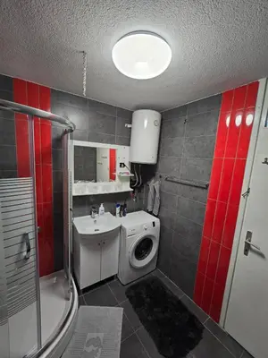 a bathroom with a washing machine and a sink at Apartman Lea in Železnička Stanica Incel
