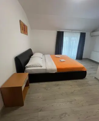 a bedroom with a bed with an orange blanket at Motel Jelić in Kraševo