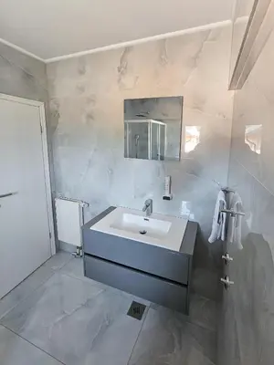 a white bathroom with a sink and a mirror at Motel Jelić in Kraševo