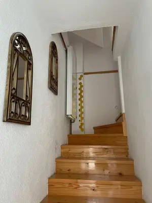 a hallway with wooden stairs and a mirror on the wall at Visoko City Apartment in Visoko