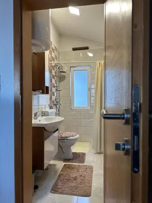 a bathroom with a toilet and a sink and a shower at Visoko City Apartment in Visoko