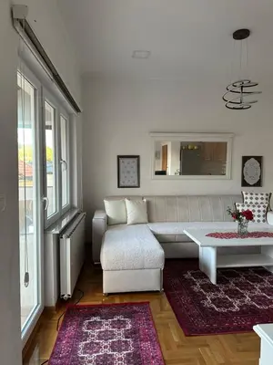 a living room with a white couch and a table at Visoko City Apartment in Visoko