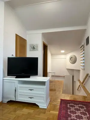a living room with a television on a white dresser at Visoko City Apartment in Visoko