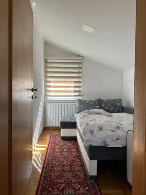 a small bedroom with a bed and a rug at Visoko City Apartment in Visoko