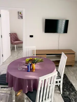 a table with a purple table cloth and fruit on it at Apartmani Ikanović in Cazin