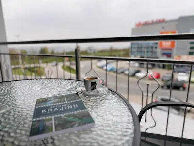 a cup of coffee sitting on a table on a balcony at Apartmani Ikanović in Cazin