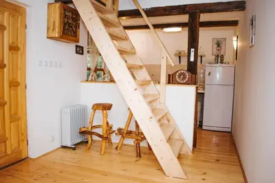 a wooden staircase in a kitchen with a refrigerator at Koliba Brezova šuma in Čović Polje