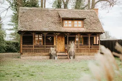 a small wooden house in a yard with a porch at Koliba Brezova šuma in Čović Polje