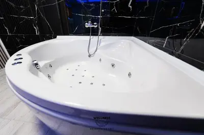 a bath tub with a shower in a bathroom at Heaven Heart - Apartmani Tuzla in Tuzla