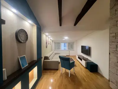 a living room with a clock and a couch at Apartman King centar in Banja Luka