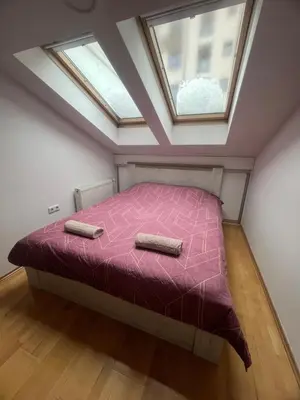 a bedroom with a pink bed with two windows at Apartman King centar in Banja Luka