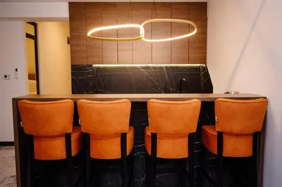a bar with orange chairs in a room at Apartmani VIZIJA in Visoko