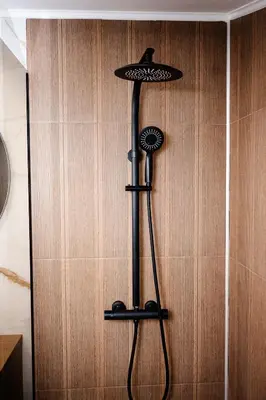 a shower in a bathroom next to a wall at Apartmani VIZIJA in Visoko