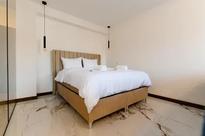 a bedroom with a large bed with white sheets at Apartmani VIZIJA in Visoko