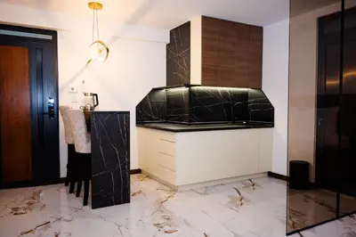 a kitchen with marble floors and a black and white counter at Apartmani VIZIJA in Visoko