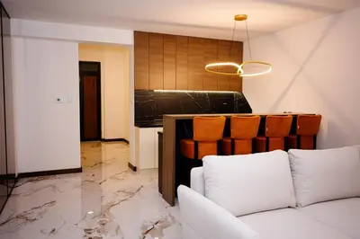 a living room with a couch and a kitchen at Apartmani VIZIJA in Visoko