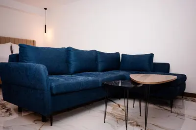 a blue couch in a living room with a table at Apartmani VIZIJA in Visoko