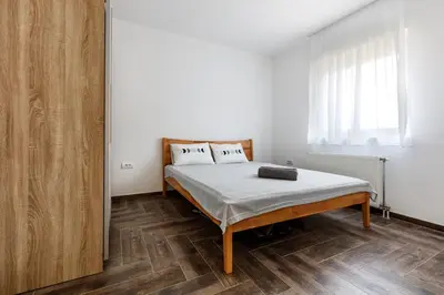 a bedroom with a bed and a large window at Vila Roda in Banja Luka