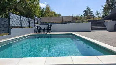 a swimming pool with two chairs and a table at Vila Roda in Banja Luka