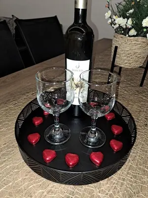 a black plate with two glasses and a bottle of wine at Vila Roda in Banja Luka