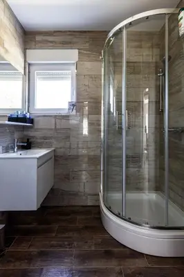 a bathroom with a shower and a tub and a sink at Vila Roda in Banja Luka