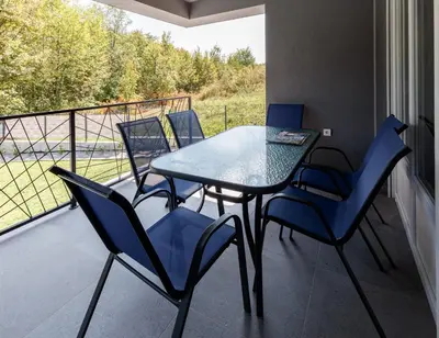 a table and chairs on a balcony with a view at Vila Roda in Banja Luka