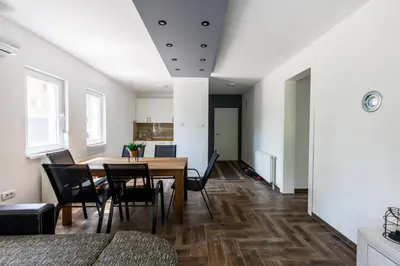 a dining room and living room with a table and chairs at Vila Roda in Banja Luka