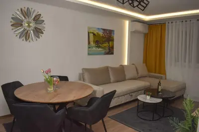a living room with a couch and a table and chairs at Apartman PLAN B in Banja Luka