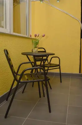 a table and two chairs and a vase of flowers at Apartman PLAN B in Banja Luka
