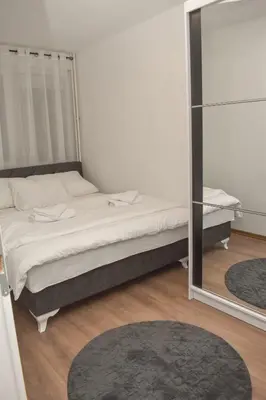 a bedroom with a bed and a mirror at Apartman PLAN B in Banja Luka
