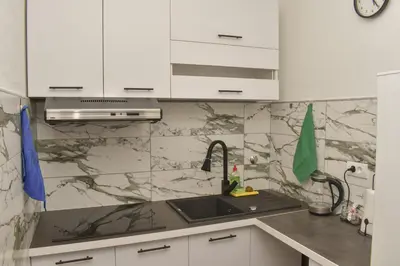 a kitchen with a sink and white cabinets at Apartman PLAN B in Banja Luka