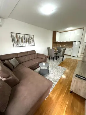 a living room with a brown couch and a table at Apartman River - stan na dan Gradiška in Bosanska Gradiška