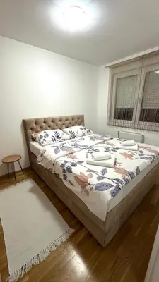 a bedroom with a bed with a comforter on it at Apartman River - stan na dan Gradiška in Bosanska Gradiška
