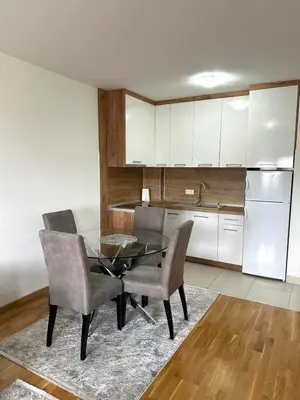a kitchen with a glass table and chairs in a room at Apartman River - stan na dan Gradiška in Bosanska Gradiška
