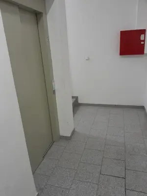 a hallway with white walls and a tile floor at VA Apartmani Živinice in Živinice