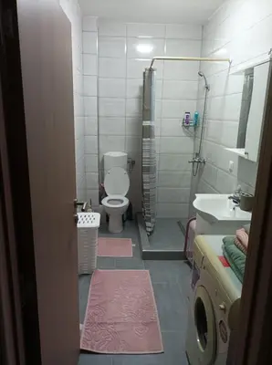 a bathroom with a toilet and a sink and a shower at VA Apartmani Živinice in Živinice