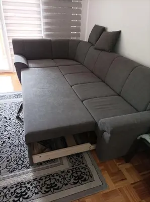 a gray couch in a living room with a table at VA Apartmani Živinice in Živinice