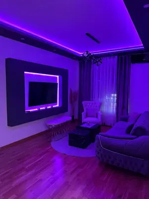 a purple living room with a couch and a tv at Spa stan na dan in Banja Luka