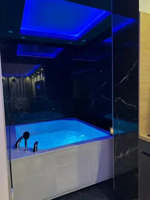 a bathroom with a blue tub with a sink at Spa stan na dan in Banja Luka