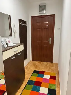a room with a brown door and a colorful rug at Apartman KIKA in Banja Luka