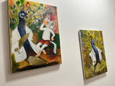 two paintings of a cat and a peacock on a wall at Apartman KIKA in Banja Luka