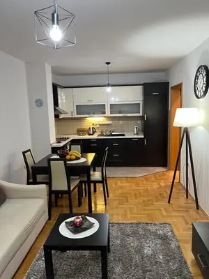 a living room with a couch and a table and a kitchen at Apartman KIKA in Banja Luka
